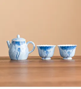 Hand-painted blue lotus ceramic teapot and cups detail view for tea tasting scene.