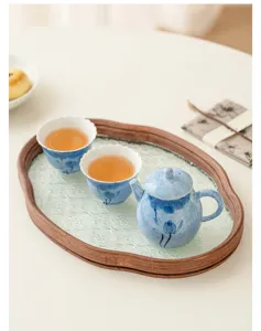 Handmade blue lotus ceramic teapot set detail showing exquisite painting and textured glass tea tray.