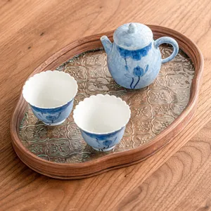 Hand-painted blue lotus ceramic tea set with a teapot, two cups, and a wooden tray.