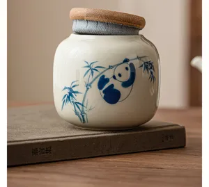 Détail de boîte à thé en céramique peinte à la main, motif panda mignon et couvercle en bois.