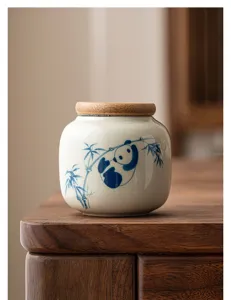 Gros plan détaillé sur le pot à thé en céramique avec motif de panda et bambou peint main.