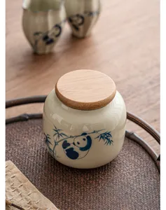 Détail de boîte à thé en céramique, motif panda bambou avec couvercle en bois.