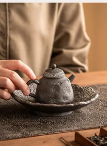 Rustikales Ton Teekanne und Untertasse Set mit geometrischen Mustern für traditionellen Tee.