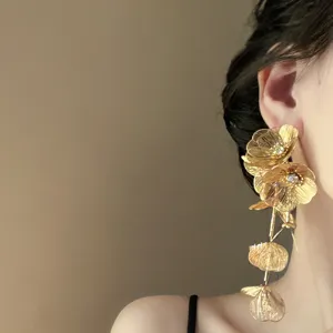 Exaggerated gold flower tassel earrings for women, metallic rhinestone statement ear jewelry.
