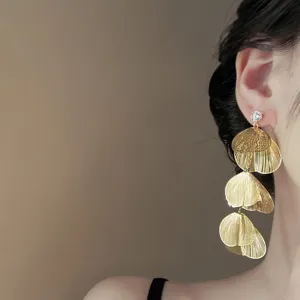 Detail shot of exquisite multi-layer petal tassel earrings with sparkling rhinestone stud design.