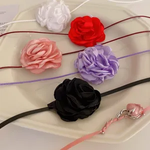 Vue détaillée de colliers ras de cou en roses de tissu multicolores présentés sur une assiette.