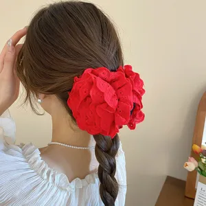 Primer plano detallado de la elegante pinza para el cabello roja con diseño de rosa.