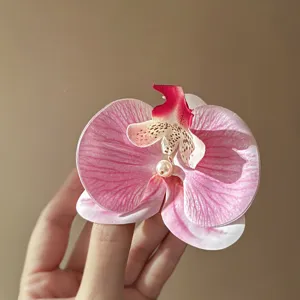 Süße rosa Orchideen-Haarnadel Detailaufnahme mit Perlenakzent für verspielte und hübsche Frisuren.