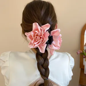 Detalle de pinza de pelo de rosa de tela rosa, elegante pinza floral para peinado de mujer.