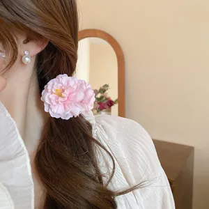 Detalle de pinza de pelo de flor rosa para un peinado elegante de uso diario chic.