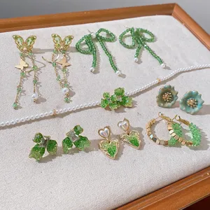 Green crystal pearl jewelry set detail showing butterfly and heart earrings with delicate craft.