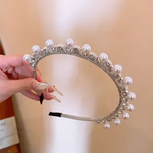 Primo piano dettagliato del cerchietto in argento con perle e strass dai dettagli luminosi.