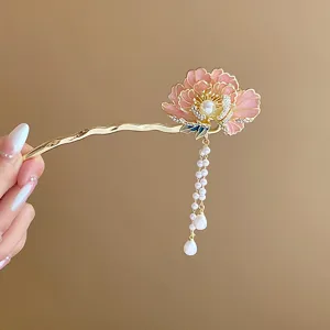 Close-up detail of a Chinese style enamel pink flower hair stick with pearl tassels.