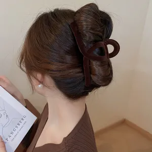 Scatto dettagliato di un'elegante molletta per capelli geometrica in velluto marrone su acconciatura.