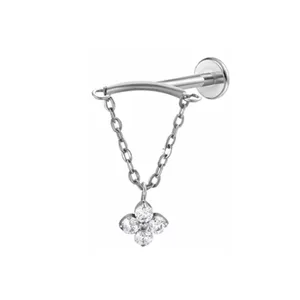 Titanium piercing detail view, featuring curved bar, hanging chains and sparkling clover pendant.