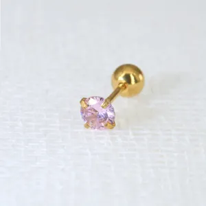 Nahaufnahme eines goldenen Edelstahl-Ohrsteckers mit funkelndem rosa Zirkonia-Stein.