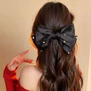 French black satin bow hair clip with crystal stars, elegant vintage hair accessory detail.