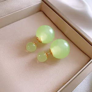 Eleganti orecchini con sfere di vetro bifacciali con perni dorati e design chic.