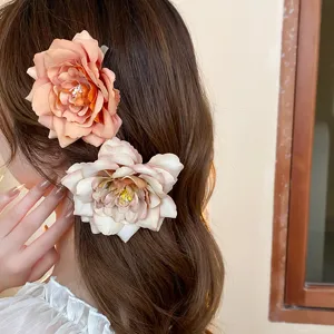 Close-up detail shot of elegant fabric rose hair clips worn on side hair, sweet and stylish.