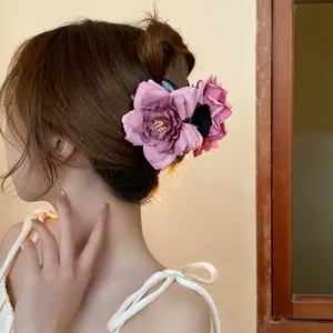 Pink rose hair claw clip for elegant updo, floral shark hair accessory for women styling.