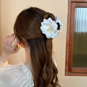 Detailed shot of a sweet white rose hair claw clip, elegant floral design for charming hairstyles.