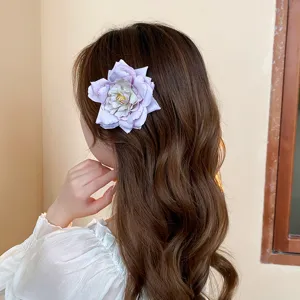 Detailed shot of a sweet light purple fabric rose hair clip, elegant side hair accessory.