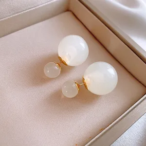 Eleganti orecchini con sfere di vetro a doppio lato e perno dorato in stile minimalista.