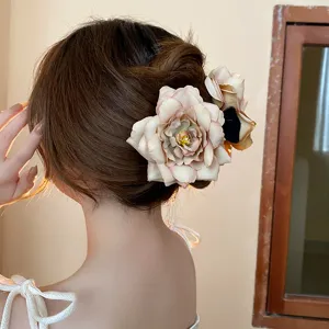 Detailed view of a sweet dried rose flower hair claw clip, elegant updo hair accessory for women.