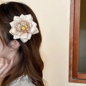 Detailed shot of a dried rose flower hair clip, featuring multi-layer petals and duckbill clip.
