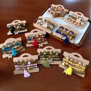 Bohemian multilayer wooden bead bracelets set with tassel and butterfly charms on display cards.