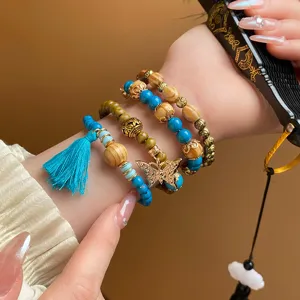 Bohemian multi-layer wooden bead bracelet detail, featuring blue beads and cute butterfly charm.