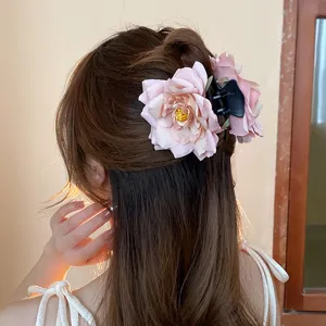 Detailed view of pink rose hair claw clip, elegant floral hair accessory for sweet hairstyles.