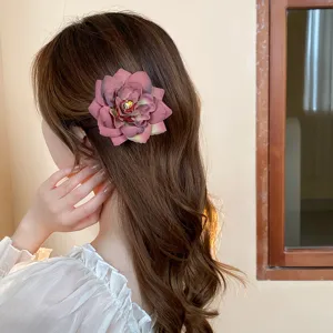 Detailed view of a sweet vintage dried rose flower hair clip, charming side hair accessory.