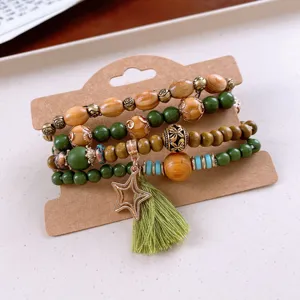 Bohemian multi-layer wooden bead bracelet detail, featuring green beads and star tassel charm.