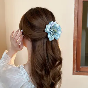 Beautiful blue fabric rose hair clip detail, elegant floral side hair accessory for women.