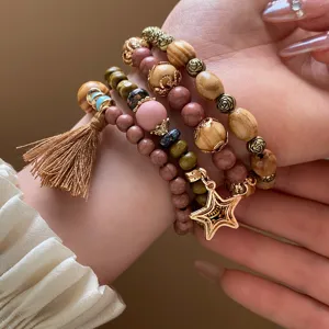Bohemian multi-layer wooden bead bracelet detail, vintage tassel star pendant hand jewelry accessory.
