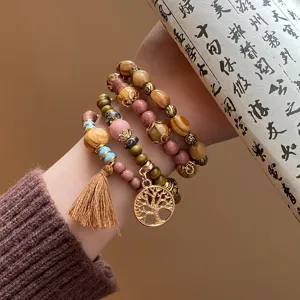 Bohemian multi-layer wooden bead bracelet with tassel and tree pendant, chic design.