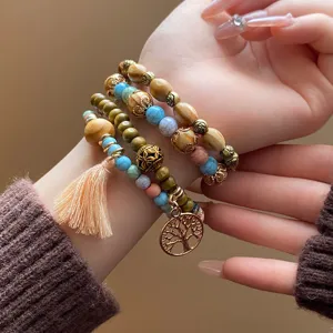 Bohemian multi-layer wooden bead bracelet detailed close up view with tassel and pendant.