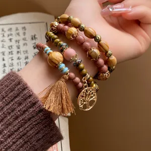 Bohemian multi-layer wooden bead bracelet with tassel and tree pendant detail view.