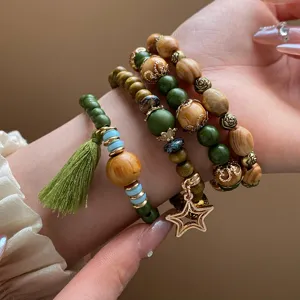 Bohemian multi-layer wooden bead bracelet set with tassel and star charm detail view.