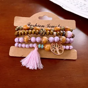 Close-up detail of bohemian multi-layer wooden bead bracelet with tree of life pendant and tassel.