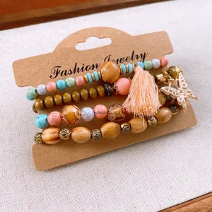Bohemian multi-layer wooden bead bracelet set with tassel and butterfly charm, detail view.