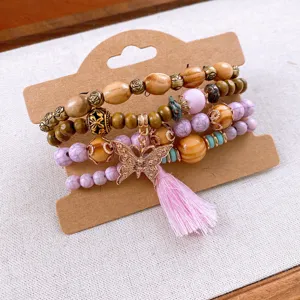 Bohemian multi-layer beaded bracelet detail featuring wooden stones and pink tassel charm.