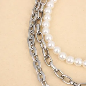 Close up detail of multi-layer punk metal chain and faux pearl waist jewelry decoration.