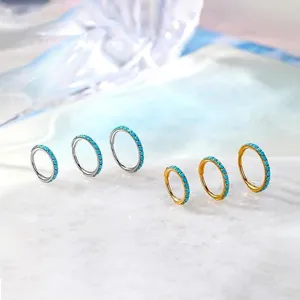 Titanium opal hoop piercing jewelry detail, showing silver and gold rings close up.