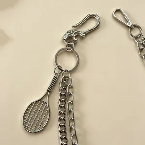 Detailansicht der silbernen Metall Hosenkette mit Tennisschläger Anhänger und Ketten.