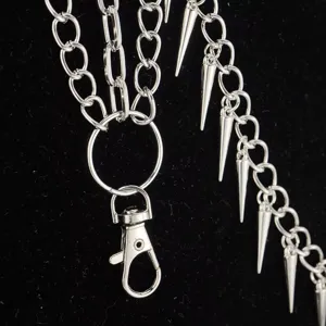 Close-up of punk style multi-layer metal trousers chain with spike pendants and clasp.
