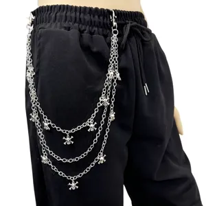 Detailed view of punk style multi-layer metal skull chain pants accessory on black trousers.