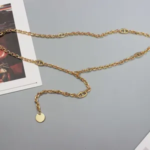 Gold metal waist chain detail featuring classic link design, stylish adjustable body chain.