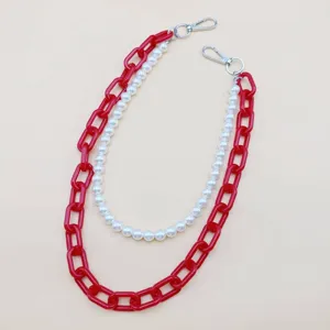 Vue detaillee de la chaine tendance en acrylique rouge et perles pour sac ou accessoire de pantalon.